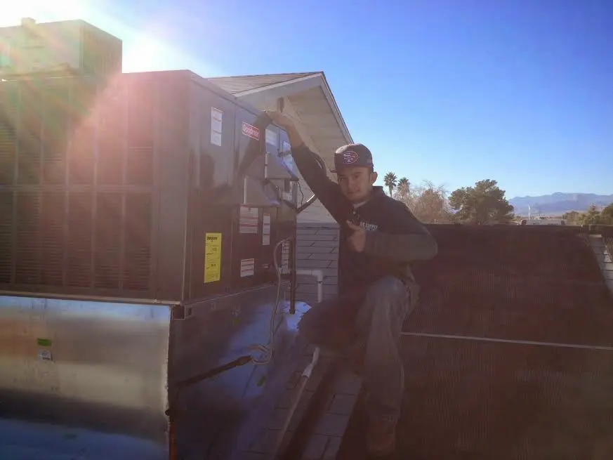 HVAC technician performing AC Tune-Up on a rooftop unit in Hampden